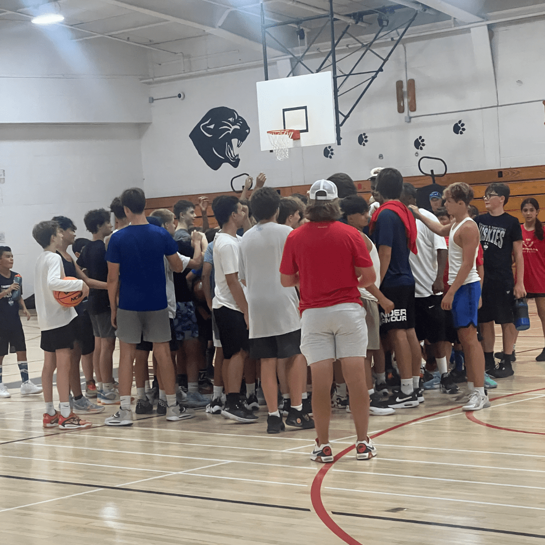 A group of people standing around in a gym.